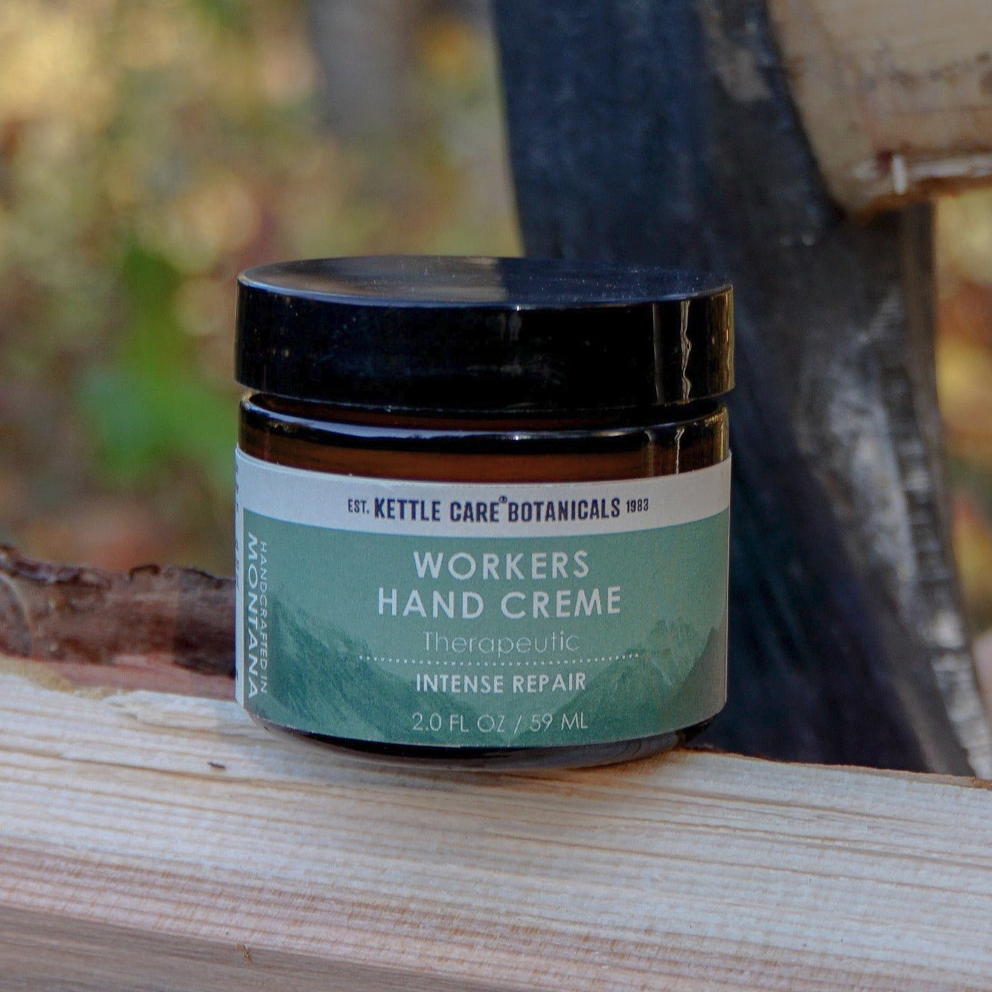 Jar of 'Workers Hand Creme' on a wooden log with a blurred natural background